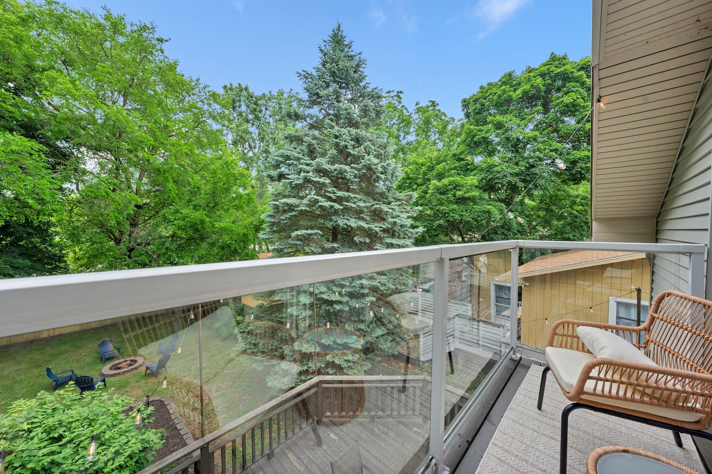 Private upper-level balcony overlooking mature trees and the backyard